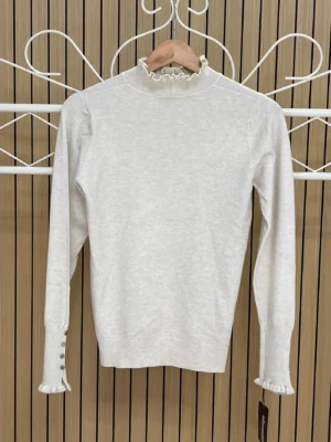 Jersey punto cuello y puños volantes botones beige