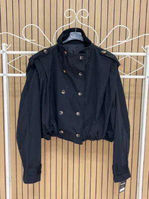 Chaqueta corta impermeable solapa hombro negra