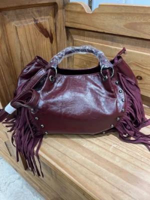 Bolso polipiel con flecos y tachuelas granate