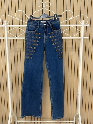Pantalón vaquero azul oscuro con botones coronel a los lados